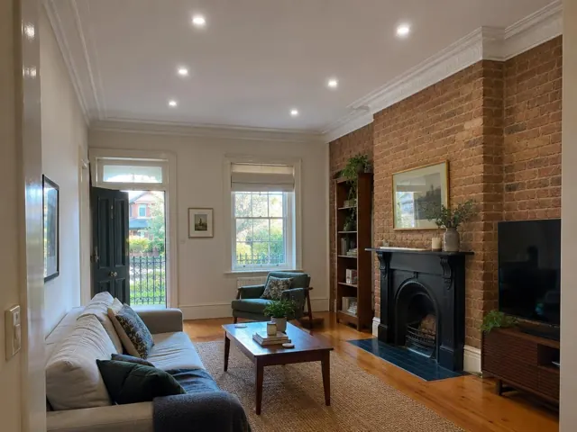 Living room ceiling with recessed downlights, brick fireplace and timber floor in Crows Nest